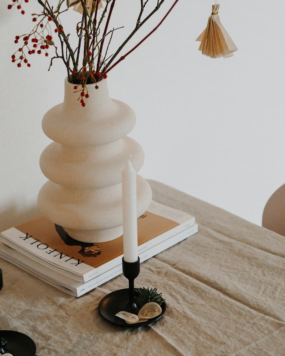 Florero de cerámica blanca con relieve acanalado y ramas secas